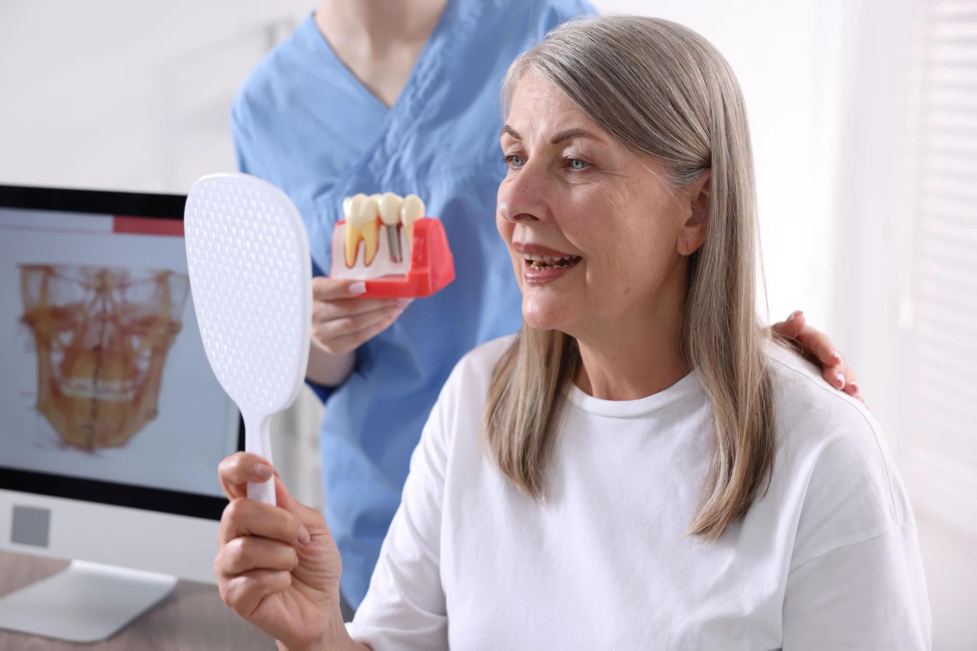 Gengive sane prima degli impianti -Donna adulta dal dentista vede i suoi impianti e le gengive sane_1920x1280